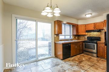Kansas City house for rent - A kitchen with brown cabinets and a black stove top oven.