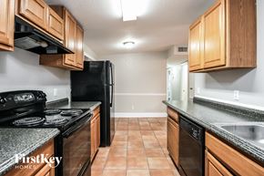 Orlando house for rent - a kitchen with wood cabinets and black appliances and granite counter tops