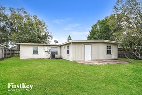 Orlando house for rent - a small white house with a grassy yard and a fence