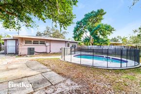 Tampa house for rent - a backyard with a pool and a house with a fence