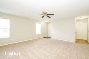 Indianapolis house for rent - A spacious room with a ceiling fan and two windows.