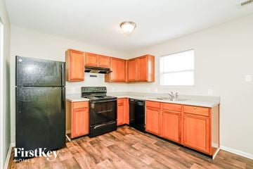 Indianapolis house for rent - A kitchen with orange cabinets and a black fridge.