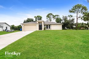 Fort Myers house for rent - a beige house with a lawn in front of it
