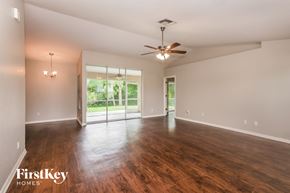 Fort Myers house for rent - an empty living room with wood flooring and a ceiling fan