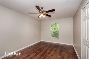 Fort Myers house for rent - a bedroom with a ceiling fan and wood floors