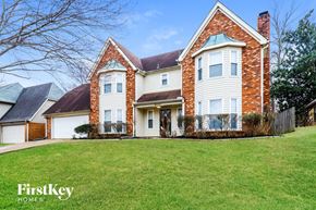 Memphis house for rent - A large brick house with a white garage door and a green lawn.