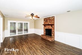 Memphis house for rent - A room with a fireplace and a ceiling fan.