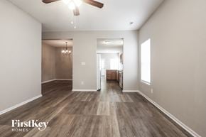Indianapolis house for rent - the living room and dining room with hardwood flooring and a ceiling fan