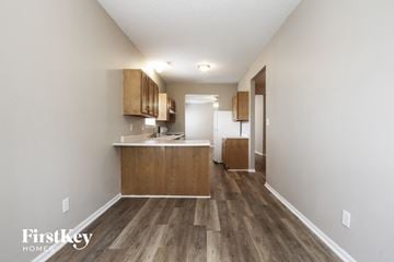Indianapolis house for rent - a kitchen with wood flooring and white walls and wooden cabinets