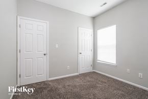 Indianapolis house for rent - a bedroom with two doors and a carpeted floor and a window