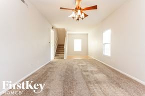 Indianapolis house for rent - A spacious room with a carpeted floor and a ceiling fan.