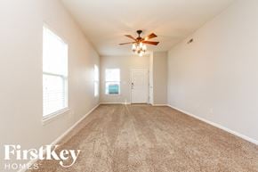 Indianapolis house for rent - A spacious room with a carpeted floor and a ceiling fan.