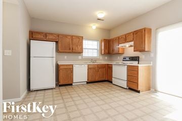 Indianapolis house for rent - A kitchen with wooden cabinets and a white refrigerator.