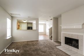 Humble house for rent - A spacious living room with a fireplace and a carpeted floor.