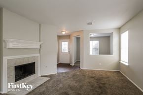 Humble house for rent - A living room with a fireplace and a carpet.