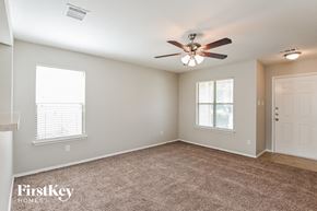 Humble house for rent - an empty living room with a ceiling fan