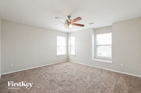 Humble house for rent - a bedroom with a ceiling fan and two windows