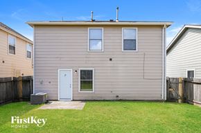 Humble house for rent - the exterior of a home with a blue door and a lawn