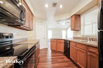 Fort Myers house for rent - a kitchen with wooden cabinets and stainless steel appliances