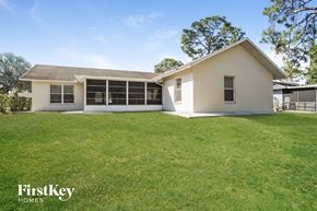 Fort Myers house for rent - a white house with a grassy yard and a lawn