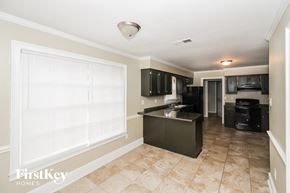 Cordova house for rent - a kitchen with black appliances and a large window