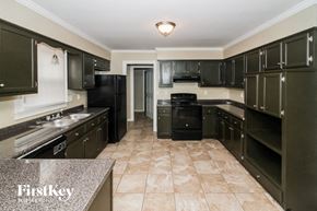 Cordova house for rent - a large kitchen with black cabinets and tile flooring and black appliances