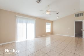Lakeland house for rent - an empty living room with a ceiling fan and a window