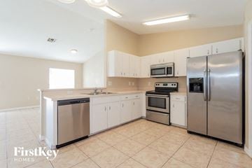 Lakeland house for rent - a large kitchen with stainless steel appliances and white cabinets