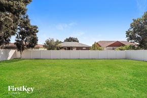 Lakeland house for rent - a backyard with green grass and a white fence