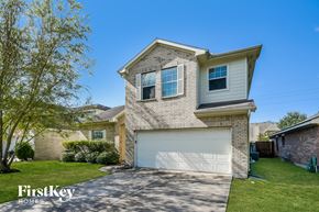 Baytown house for rent - a brick house with a white garage door and a green lawn