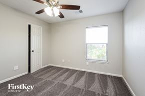 Baytown house for rent - a bedroom with a ceiling fan and a window