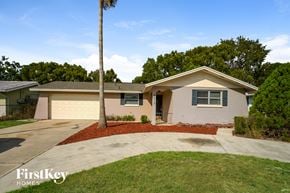 Port Richey house for rent - A house with a red mulch bed in front of it.