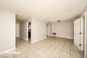 Port Richey house for rent - A spacious room with a tile floor and white walls, with a door on the right side.