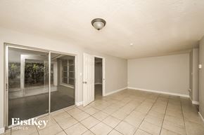 Port Richey house for rent - A room with a sliding glass door and a tiled floor.