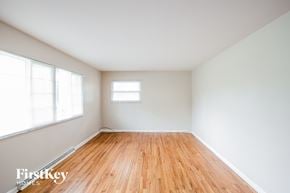 Indianapolis house for rent - Empty room with wooden floor and white walls.