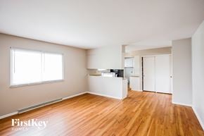 Indianapolis house for rent - A room with wooden floors and white walls, with a window on the left side.