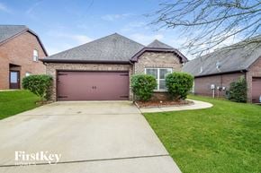 Mccalla house for rent - a brick house with a pink garage door