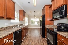 Mccalla house for rent - a kitchen with wood flooring and wooden cabinets and black appliances