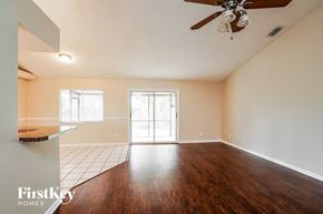 Fort Myers house for rent - A room with a ceiling fan and a large window.