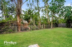 Fort Myers house for rent - A backyard with a fence and trees.