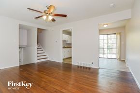 Kansas City house for rent - A spacious room with a wood floor and a ceiling fan.