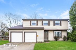 Indianapolis house for rent - the front of a tan house with two garage doors