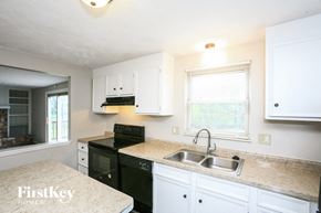 Indianapolis house for rent - a kitchen with black appliances and white cabinets