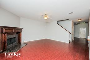 Fort Worth house for rent - A room with a fireplace and wooden floors.