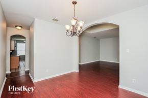Fort Worth house for rent - A large empty room with a chandelier and wooden floors.