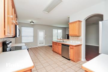 Fort Worth house for rent - A kitchen with wooden cabinets and a white countertop.
