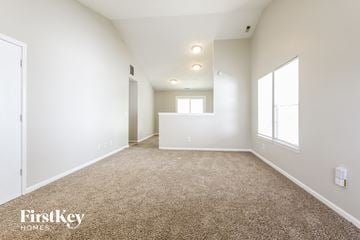 Indianapolis house for rent - a spacious living room with white walls and carpet