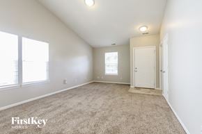 Indianapolis house for rent - a spacious living room with carpet and a white door