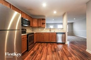 Indianapolis house for rent - A kitchen with wooden floors and a stainless steel refrigerator.
