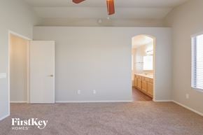 Peoria house for rent - a bedroom with a carpeted floor and a door to a bathroom